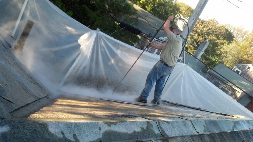 Asbestos-One employee steam cleaning asbestos roof.